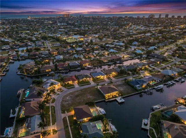 Aerial view of property's location featuring a nearby body of water and nearby suburban area