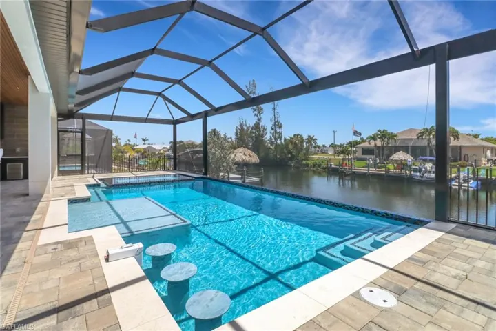 Oversized pool with sun ledge, 3 built-in bar stools and false negative edge and a 30' wide panoramic screen window