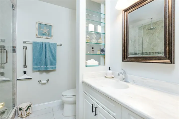 Bathroom featuring a stall shower, vanity, and light tile patterned flooring