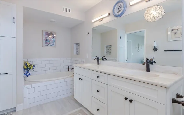 Full bathroom with dual sinks, bath tub and separate shower