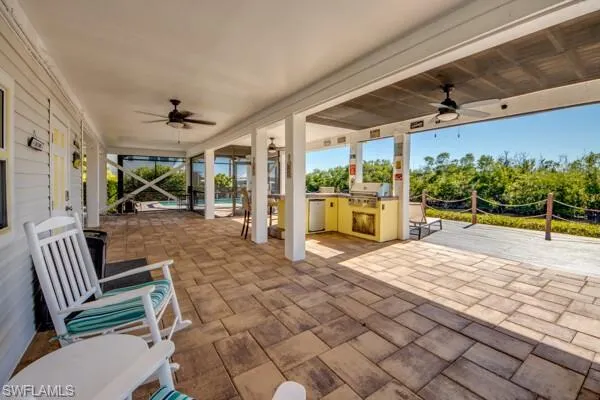 View of patio / terrace featuring a ceiling fan, an outdoor pool, and exterior kitchen