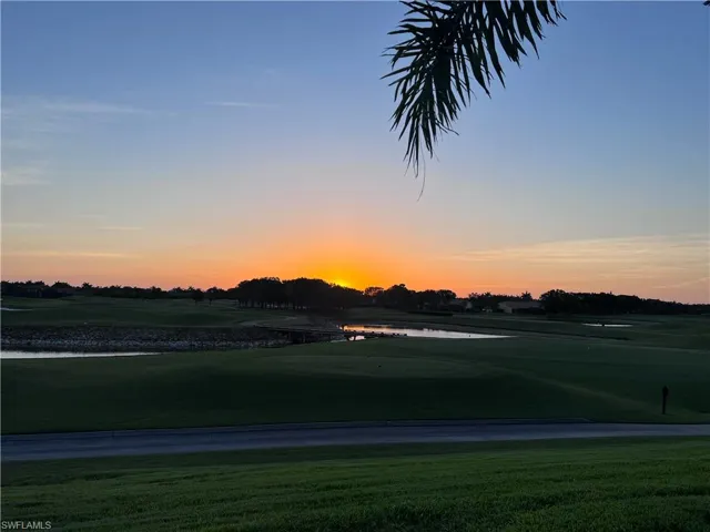 View of community featuring view of golf course, a water view, and a lawn