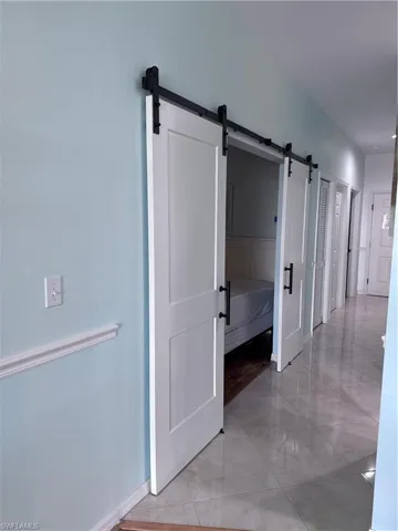Hallway with baseboards and a barn door