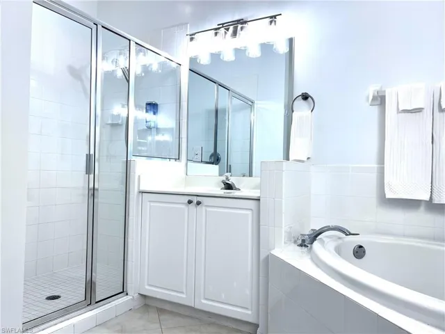 Bathroom with a shower stall, a garden tub, and vanity