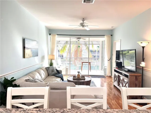 Living area with wood finished floors and ceiling fan