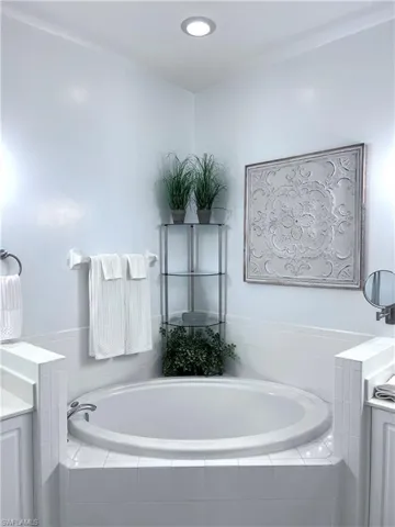 Full bathroom featuring a garden tub and vanity
