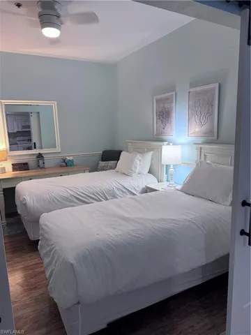 Bedroom with dark wood-type flooring and a ceiling fan