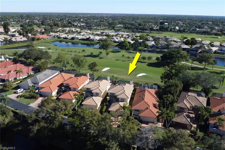 Aerial view of property and surrounding area featuring nearby suburban area and a nearby body of water