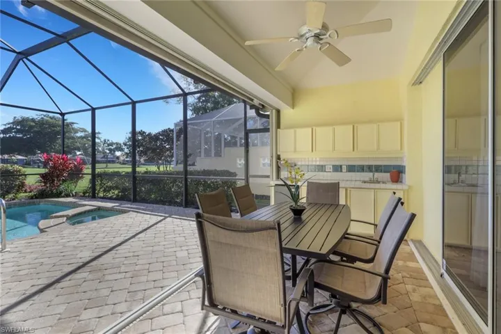 Sunroom / solarium with a patio area, ceiling fan, a hot tub, outdoor dining space, and a pool
