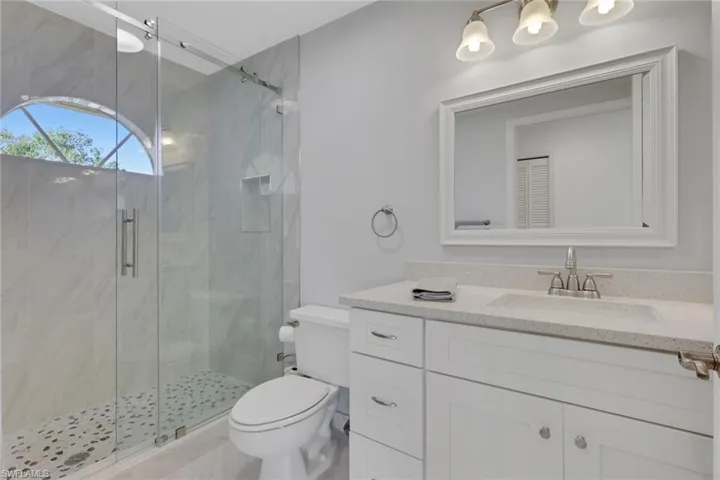 Bathroom with a marble finish shower, vanity, and marble finish flooring