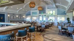 Bar area featuring lofted ceiling, pendant lighting, and light countertops