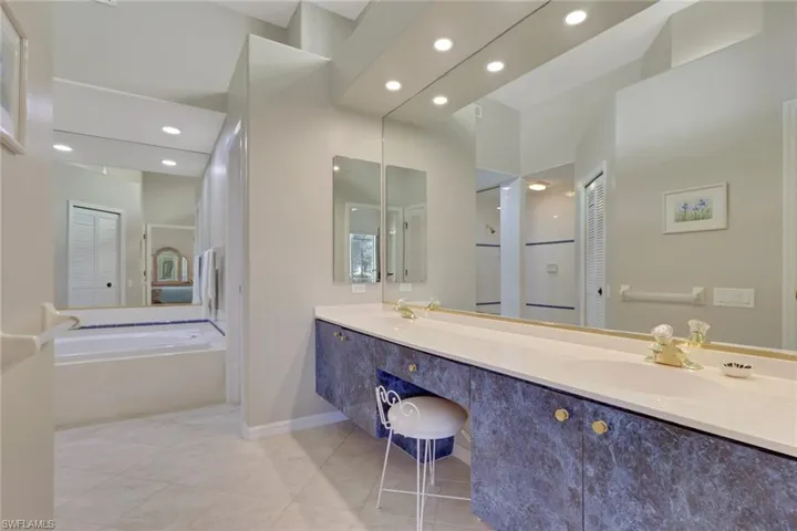 Bathroom featuring double vanity, recessed lighting, light tile patterned floors, a closet, and a garden tub