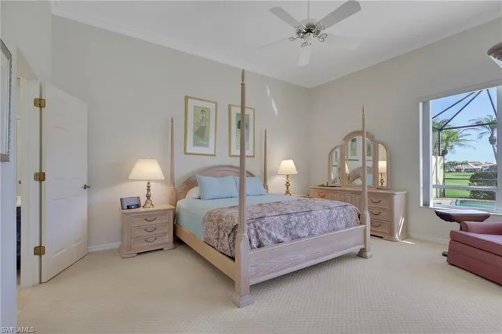 Carpeted bedroom featuring ornamental molding and ceiling fan