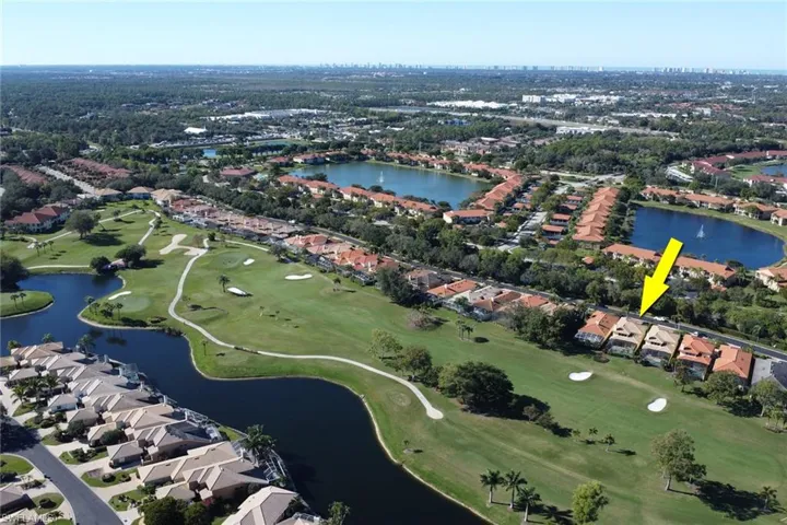 Aerial view of property and surrounding area featuring nearby suburban area and a nearby body of water