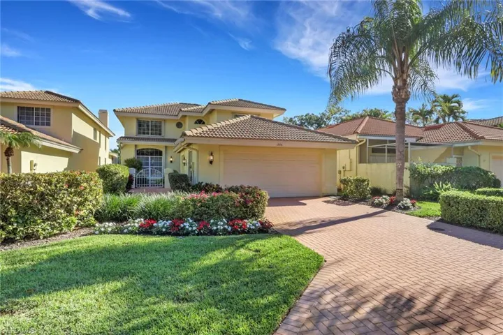 Mediterranean / spanish-style home featuring stucco siding, a front lawn, a garage, decorative driveway, and a tiled roof