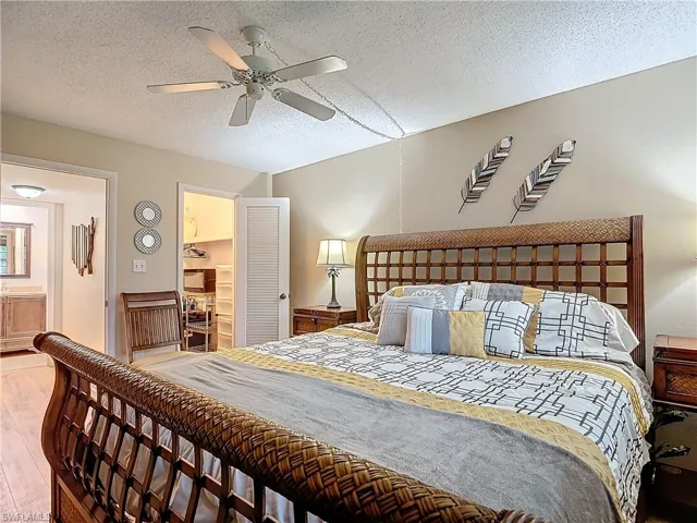 Bedroom featuring ceiling fan, wood-type flooring, and a textured ceiling