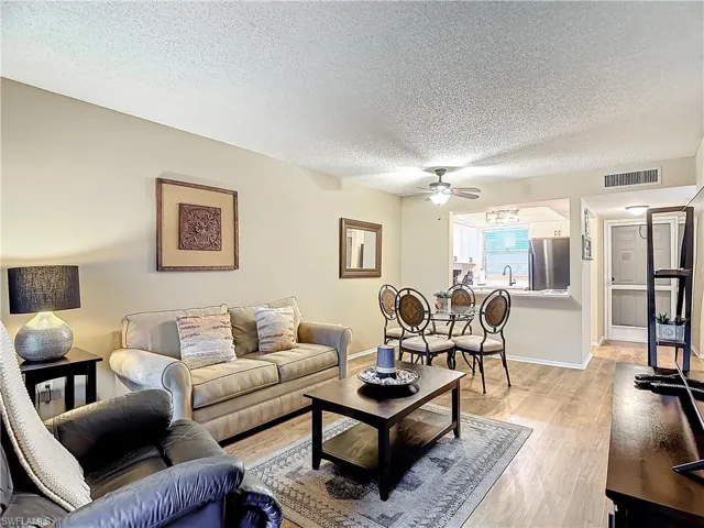 Living room with sink, a textured ceiling, ceiling fan, and light hardwood / wood-style floors