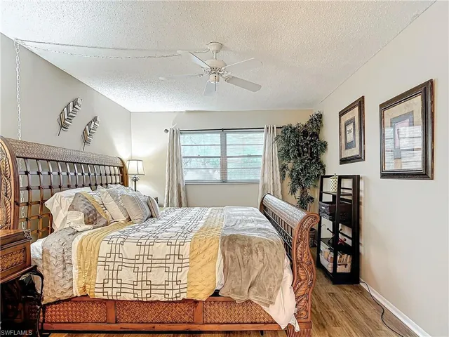 Bedroom featuring a textured ceiling, ceiling fan, and wood-type flooring
