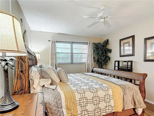 Bedroom featuring a textured ceiling, ceiling fan, and hardwood / wood-style floors