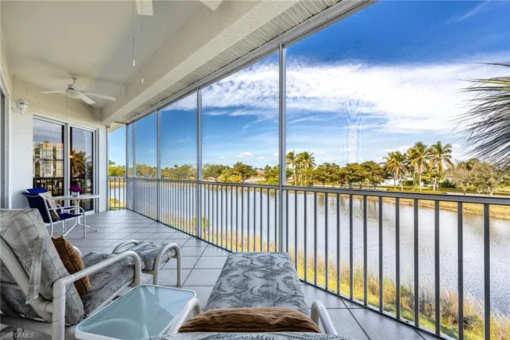 Sunroom / solarium featuring a textured wall, a water view, and tile patterned flooring
