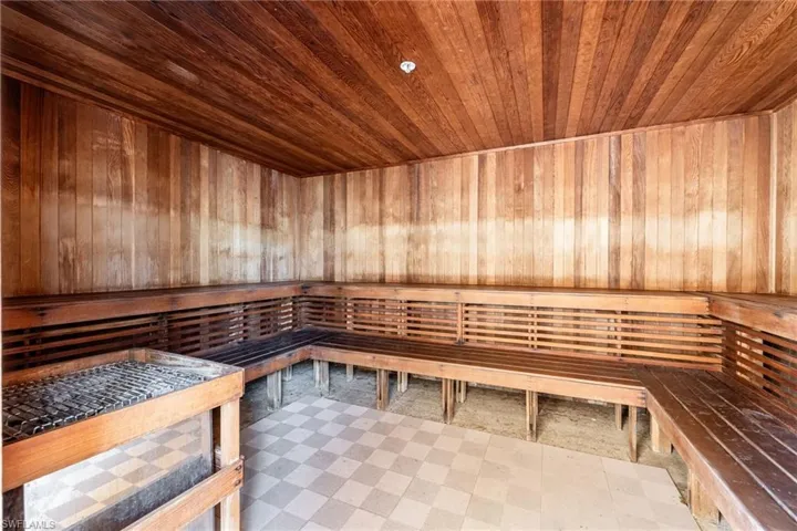 Relaxing sauna / steam room with tile patterned floors, wood walls, and wooden ceiling