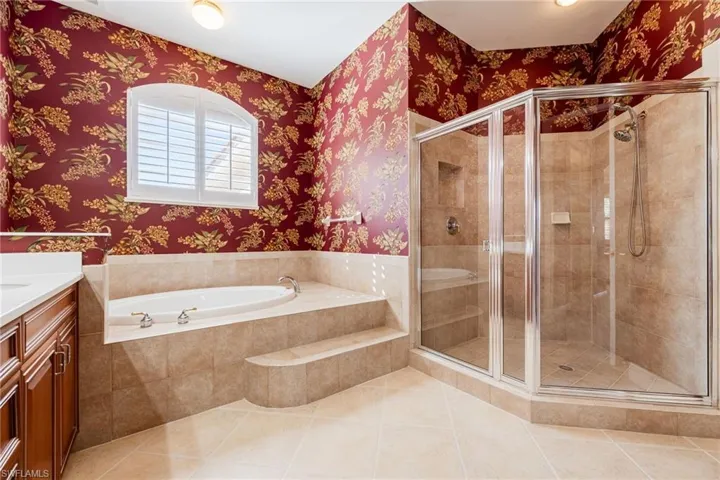 Full bath with a garden tub, a shower stall, light tile patterned floors, and vanity