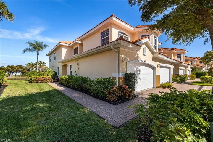 View of property exterior with stucco siding, a yard, a tile roof, an attached garage, and decorative driveway