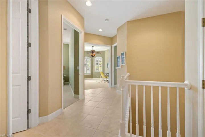 Hallway with light tile patterned floors and recessed lighting