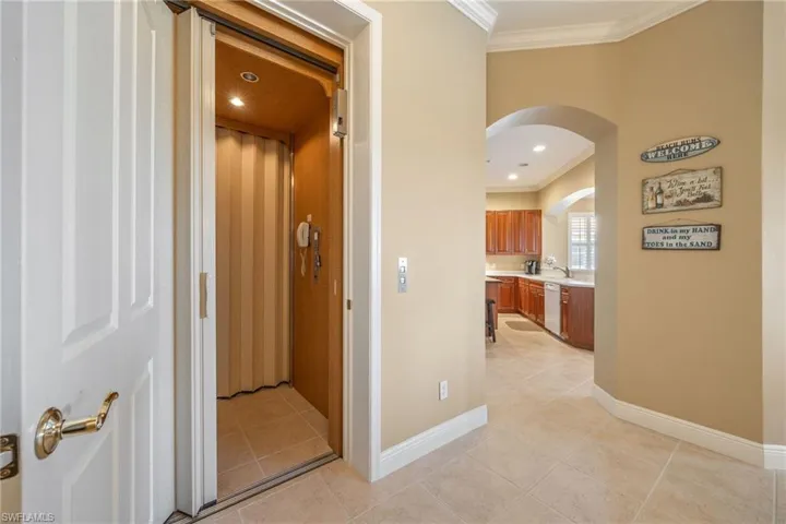 Hallway featuring ornamental molding, elevator, light tile patterned floors, and recessed lighting