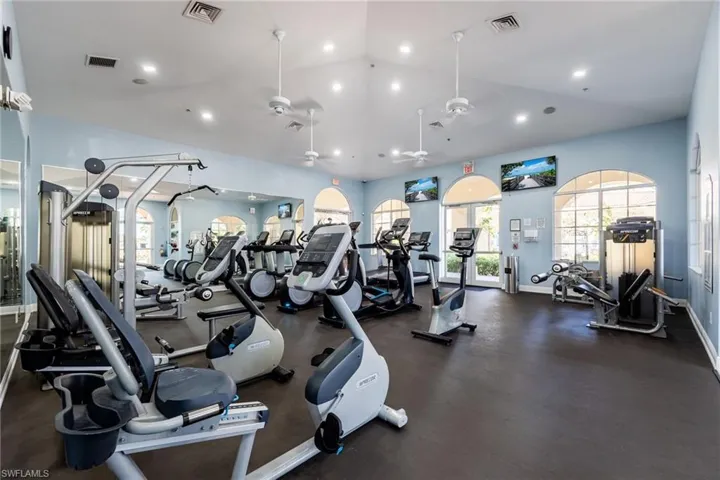 Gym with a ceiling fan, recessed lighting, and vaulted ceiling
