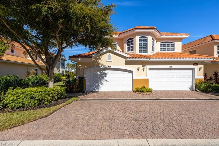Mediterranean / spanish house with stucco siding, a tile roof, decorative driveway, and an attached garage