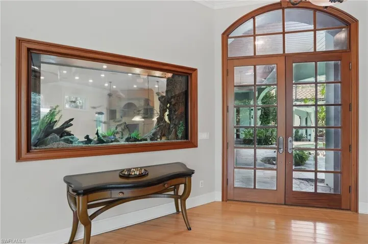 Doorway to outside featuring ornamental molding, wood finished floors, french doors, and baseboards