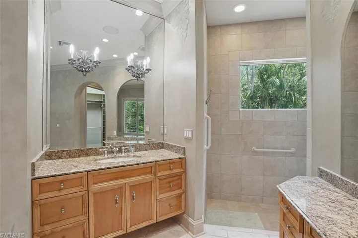 Bathroom featuring vanity, walk in shower, recessed lighting, and crown molding