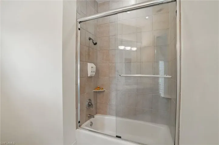 Full bathroom featuring combined bath / shower with glass door