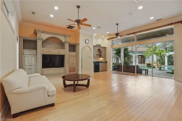 Living area with a ceiling fan, ornamental molding, recessed lighting, light wood-style floors, and baseboards