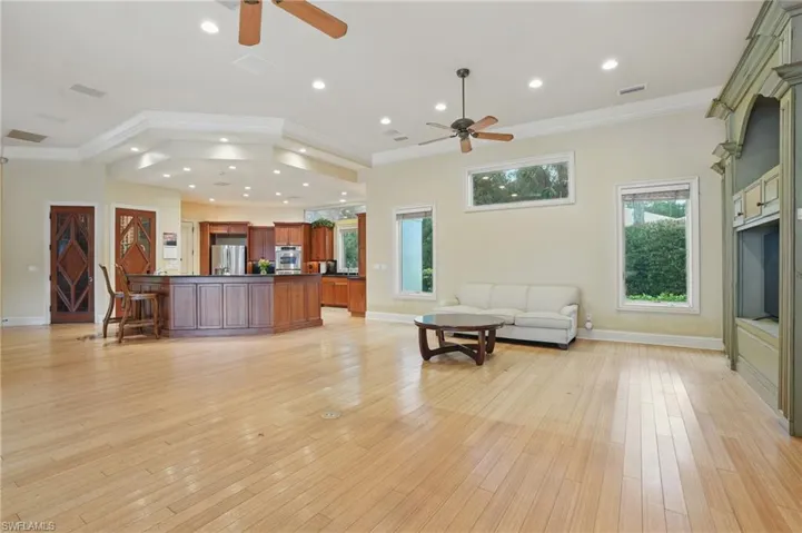 Living room featuring a ceiling fan, crown molding, light wood-style flooring, healthy amount of natural light, and recessed lighting