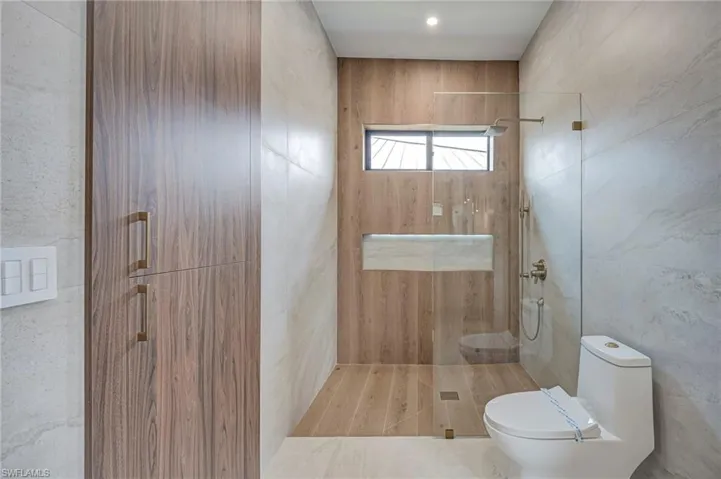 Bathroom featuring walk in shower and tile walls