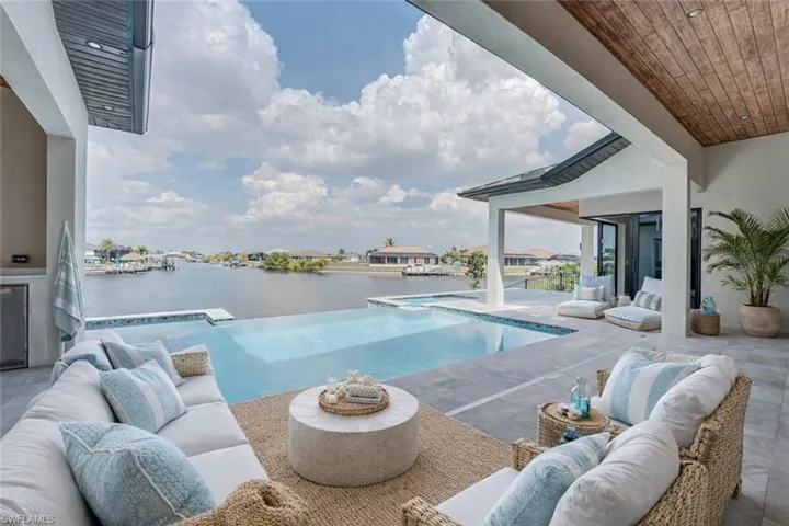 Swimming pool with an outdoor lounge area, a patio area, and a water view