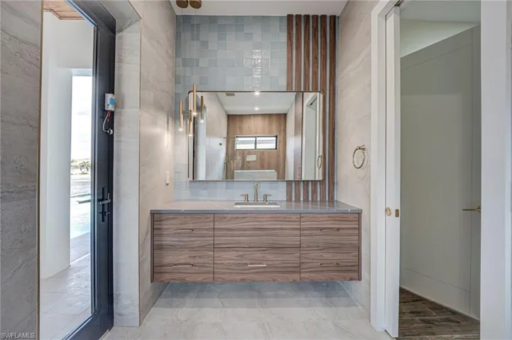 Bathroom featuring vanity and tile walls