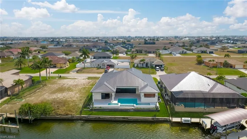 Aerial perspective of suburban area with a pool area and a nearby body of water