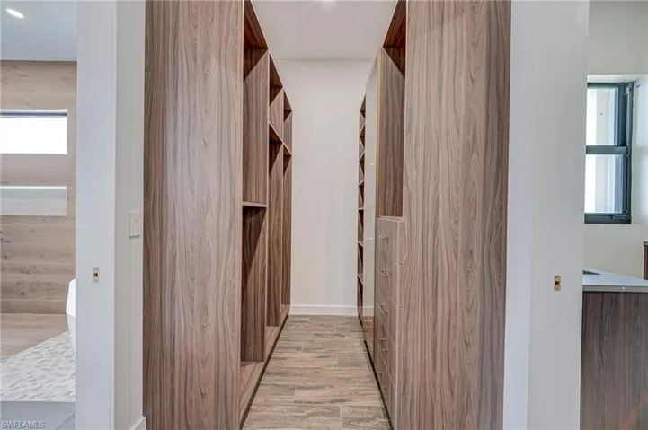 Walk in closet with light wood finished floors