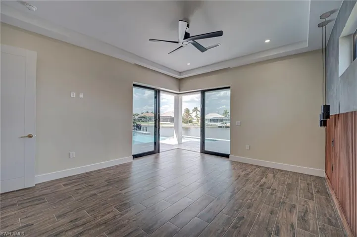Unfurnished room featuring a ceiling fan, wood tiled floors, recessed lighting, and a water view
