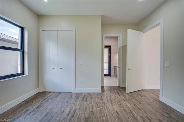 Unfurnished bedroom featuring dark wood-style floors and a closet