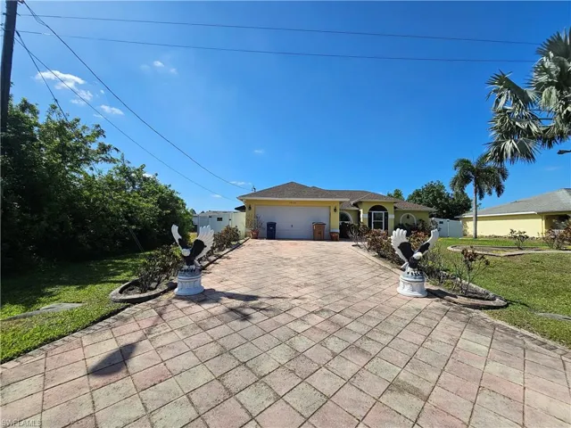 View of front of house featuring a garage, a front lawn, and driveway