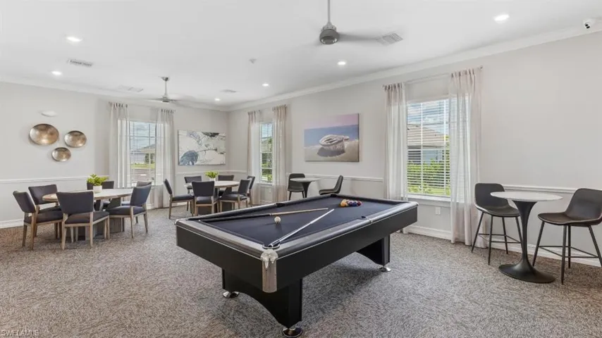 Spacious common area featuring a billiards table, recessed lighting, ceiling fans, and multiple window treatments