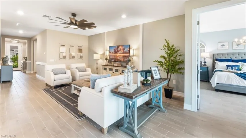 Expansive living area featuring light wood-finish flooring, recessed lighting, and a unique ceiling fan