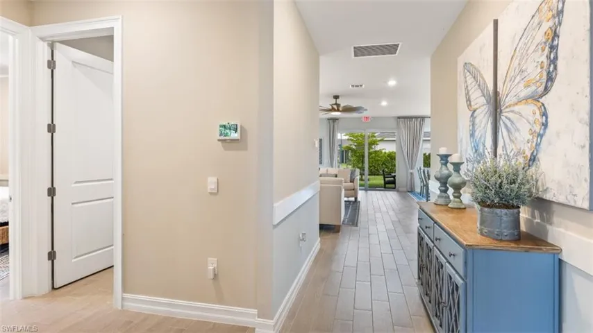 Hallway featuring wood-finish flooring, recessed lighting, and a smart thermostat
