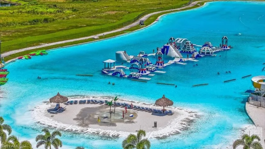 Expansive lagoon featuring a water recreation structure, sandy beach areas, and a waterside slide
