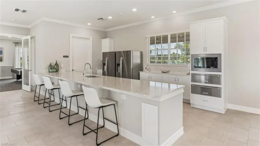 Spacious common area featuring recessed lighting, multiple ceiling fans, and large windows