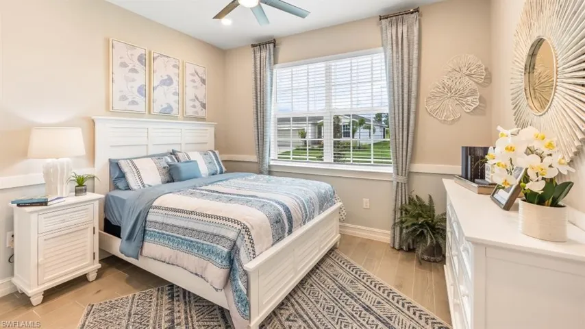 Window with horizontal blinds, overhead ceiling fan, and wood-finish flooring